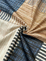 Tessuto a quadri multicolore con motivi a righe blu, marroni e beige, ideale per arredamento e moda. Materiale di alta qualità, texture morbida.