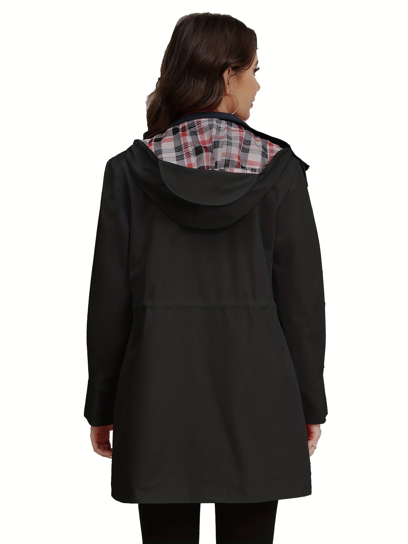 Donna con cappotto nero impermeabile, cappuccio foderato a quadri, vista posteriore. Moda autunnale, abbigliamento casual elegante.