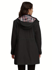 Donna con cappotto nero impermeabile, cappuccio foderato a quadri, vista posteriore. Moda autunnale, abbigliamento casual elegante.