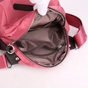 Zaino rosa in nylon aperto, con tasca interna con cerniera, spallacci regolabili e dettagli in metallo. Ideale per scuola o viaggio.