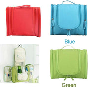 Quattro beauty case da viaggio appesi, colori rosso, blu e verde, con scomparti multipli per articoli da toeletta. Organizzatore compatto e portatile.