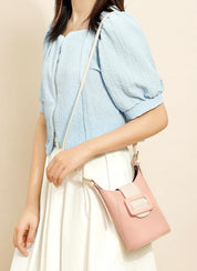 Donna con borsa a tracolla rosa, abbigliamento estivo elegante, camicetta azzurra, gonna bianca. Accessori moda femminile, stile casual chic.