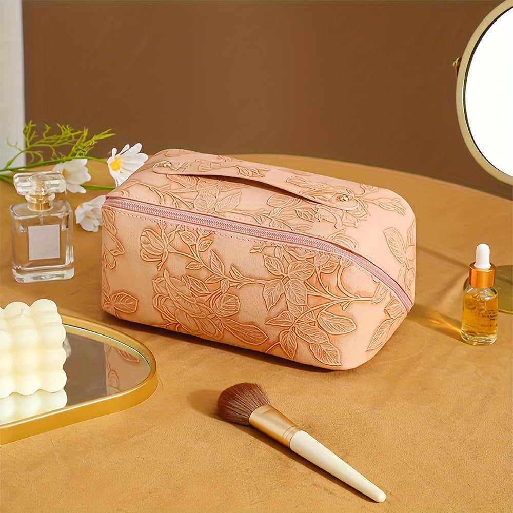 Astuccio trucco beige con motivo floreale, specchio, profumo, pennello e olio essenziale su tavolo. Accessori bellezza eleganti e funzionali.