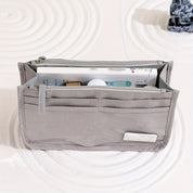 Organizer borsa grigio con tasche multiple, ideale per cosmetici e accessori. Design compatto, perfetto per viaggi e uso quotidiano.