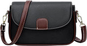 Borsa a tracolla in pelle nera con dettagli marroni, chiusura a patta, cuciture bianche, ideale per moda donna, accessorio elegante e versatile.