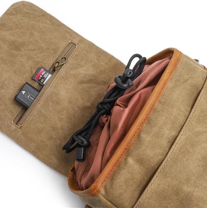 Borsa a tracolla in tela marrone con tasca interna, cerniera, schede SD e cavo. Design compatto, ideale per fotocamere e accessori.
