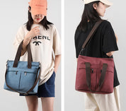 Due persone con borse a tracolla in tela, una blu e una rossa, indossano abbigliamento casual. Borse moda donna, stile urbano, pratiche e versatili.