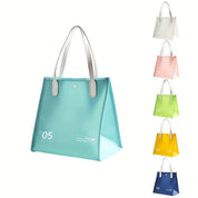 Borsa trasparente in PVC azzurro con manici bianchi, disponibile in vari colori: bianco, rosa, verde, giallo, blu. Design moderno e versatile.