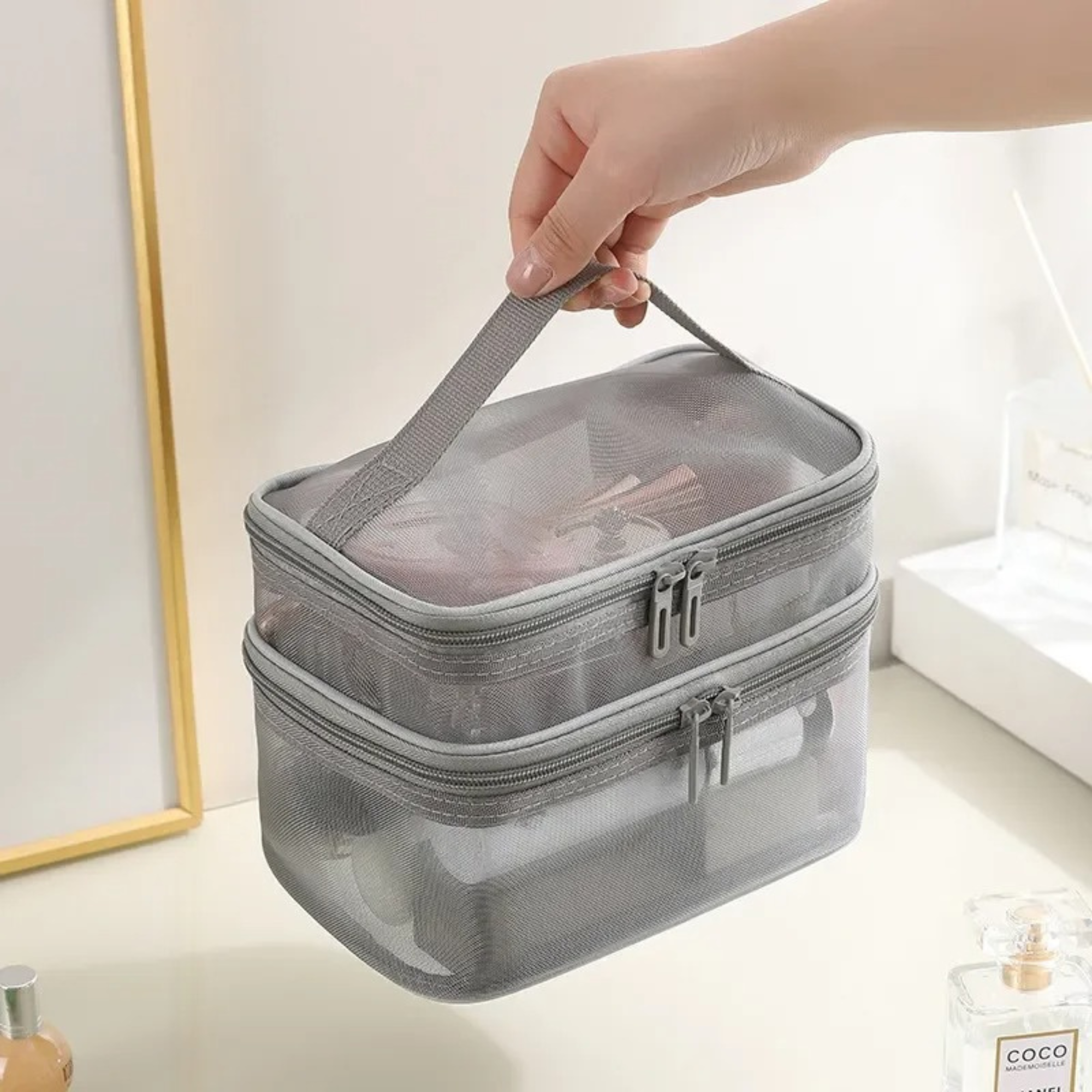 Borsa da toilette trasparente grigia con doppia cerniera, manico superiore, ideale per organizzare cosmetici e accessori da viaggio.