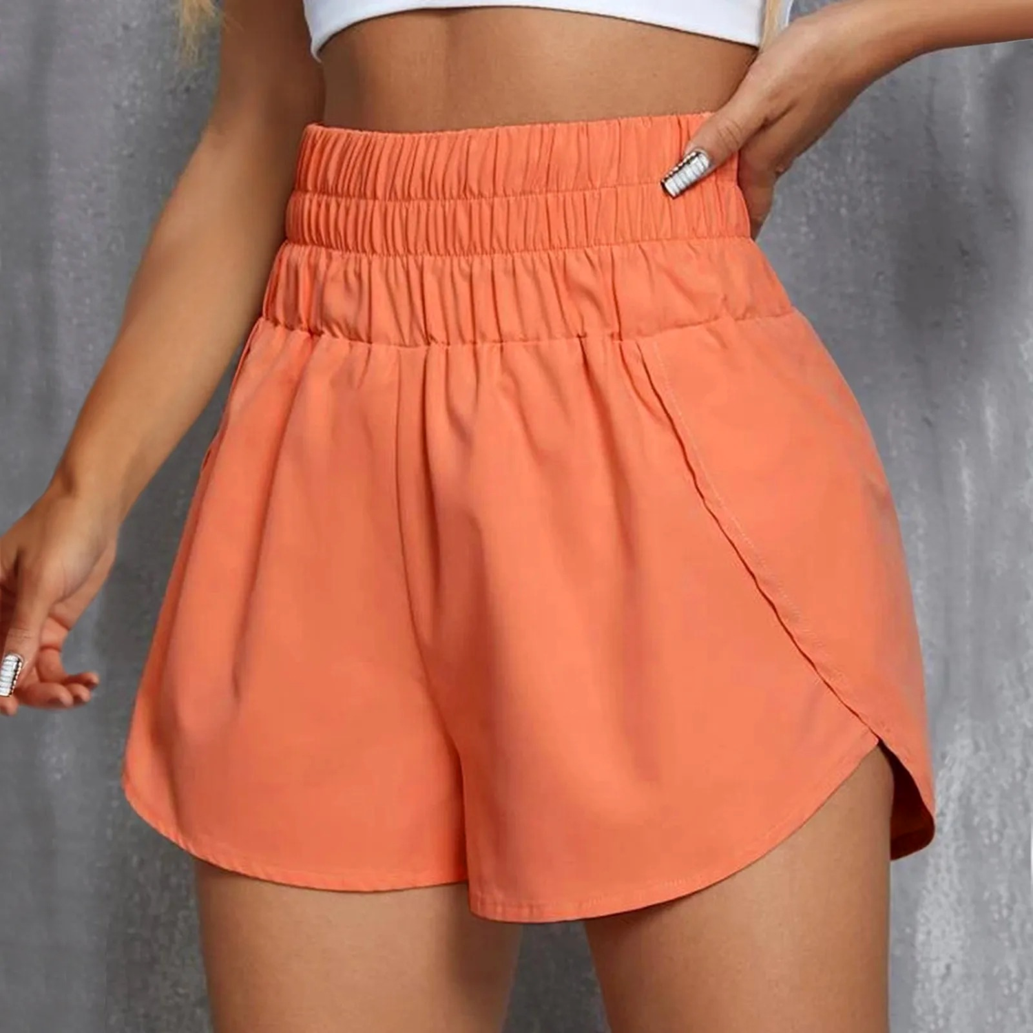 Shorts sportivi arancioni da donna, vita alta con elastico, design casual e confortevole, perfetti per attività sportive e tempo libero.