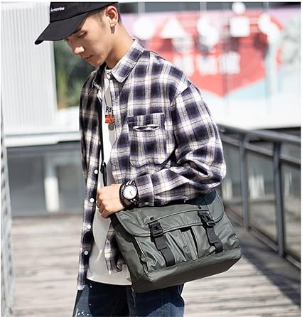 Giovane con camicia a quadri e cappello nero indossa borsa a tracolla verde. Moda urbana, accessori uomo, stile casual.