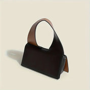 Borsa a mano in pelle nera con manico ampio marrone, design moderno ed elegante. Accessorio moda donna, ideale per look sofisticati.