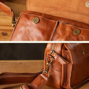 Borsa a tracolla in pelle marrone con chiusure a bottone e cerniera, dettagli in metallo dorato, design elegante e artigianale.