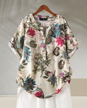 Camicia donna floreale in cotone, maniche corte, colletto a V, bottoni, sfondo beige, design casual, perfetta per primavera ed estate.
