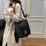 Donna con zaino nero elegante, design moderno, indossa cappotto beige. Accessorio moda femminile, perfetto per ufficio o viaggio.