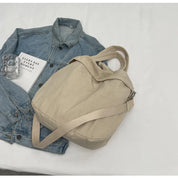 Giacca di jeans blu con borsa a tracolla beige su sfondo bianco, moda casual, accessori donna, stile urbano, tendenze 2023.