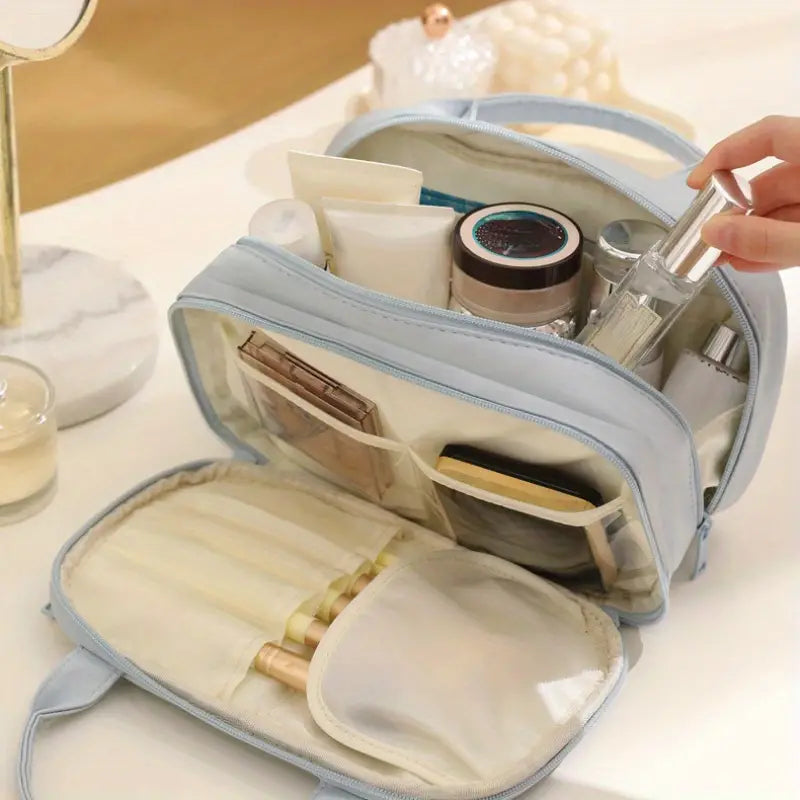 Borsa da trucco azzurra aperta con cosmetici e prodotti di bellezza, tra cui flaconi, creme e pennelli, su un tavolo da toeletta elegante.