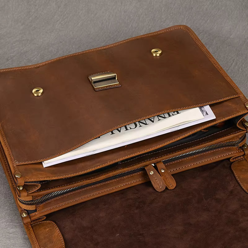 Cartella in pelle marrone aperta, con scomparti multipli e documenti all'interno, su sfondo grigio. Elegante e funzionale per lavoro e ufficio.