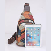 Zaino a tracolla multicolore con motivo geometrico, accanto a un tablet. Design moderno, ideale per viaggi e uso quotidiano. Accessori moda unisex.