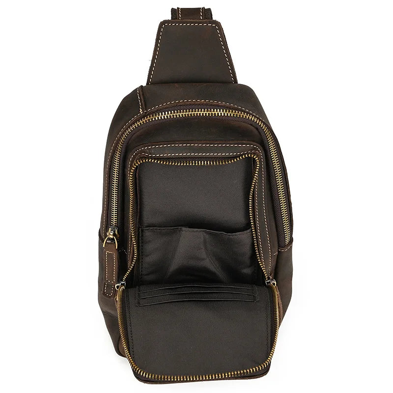 Zaino a tracolla in pelle marrone con cerniere dorate, tasca frontale aperta e cuciture a contrasto. Design elegante e pratico per uomo e donna.