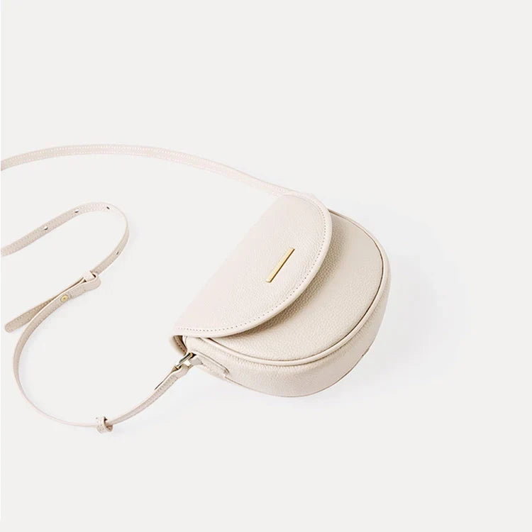 Borsa a tracolla in pelle beige, design elegante e minimalista, chiusura con patta, ideale per moda donna, accessorio versatile e chic.