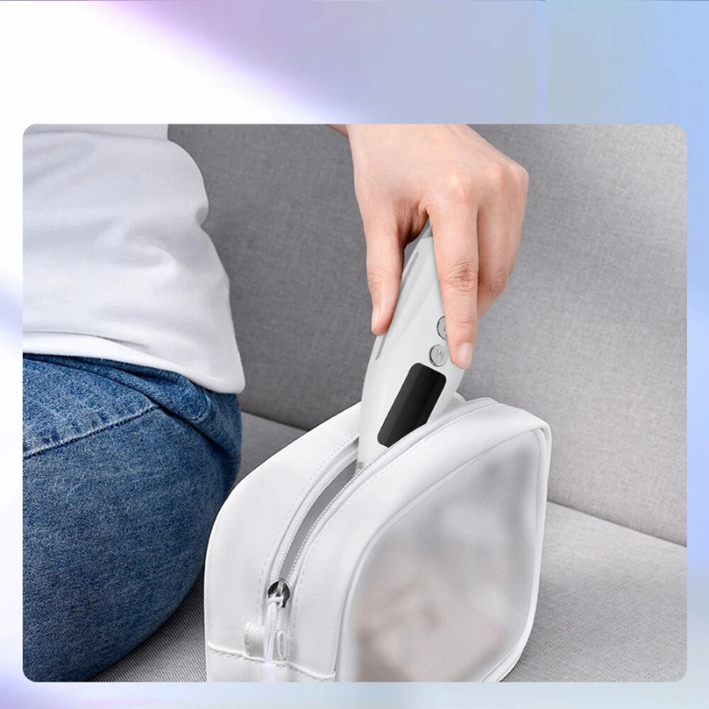 Utensile per la cura della pelle bianco, portatile, con display digitale, riposto in una borsa da viaggio bianca su un divano grigio.