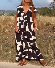 Donna con abito lungo estivo bianco e nero, motivo astratto, in campagna. Moda femminile, abbigliamento casual, stile estivo.