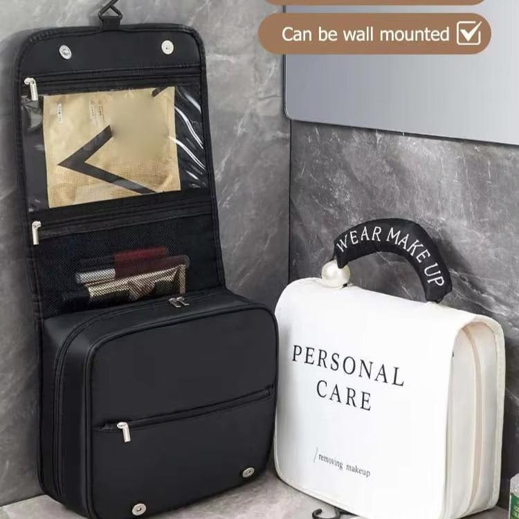 Borsa da viaggio per trucco nera e bianca, appendibile, con scomparti trasparenti e tasche multiple, ideale per organizzare cosmetici e accessori.
