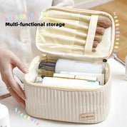 Astuccio cosmetico beige multiuso aperto con pennelli trucco e prodotti skincare, ideale per organizzazione e viaggio.