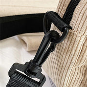Gancio in plastica nera su borsa a tracolla beige in tessuto a coste. Accessorio moda, dettaglio chiusura sicura. Borsa casual elegante.