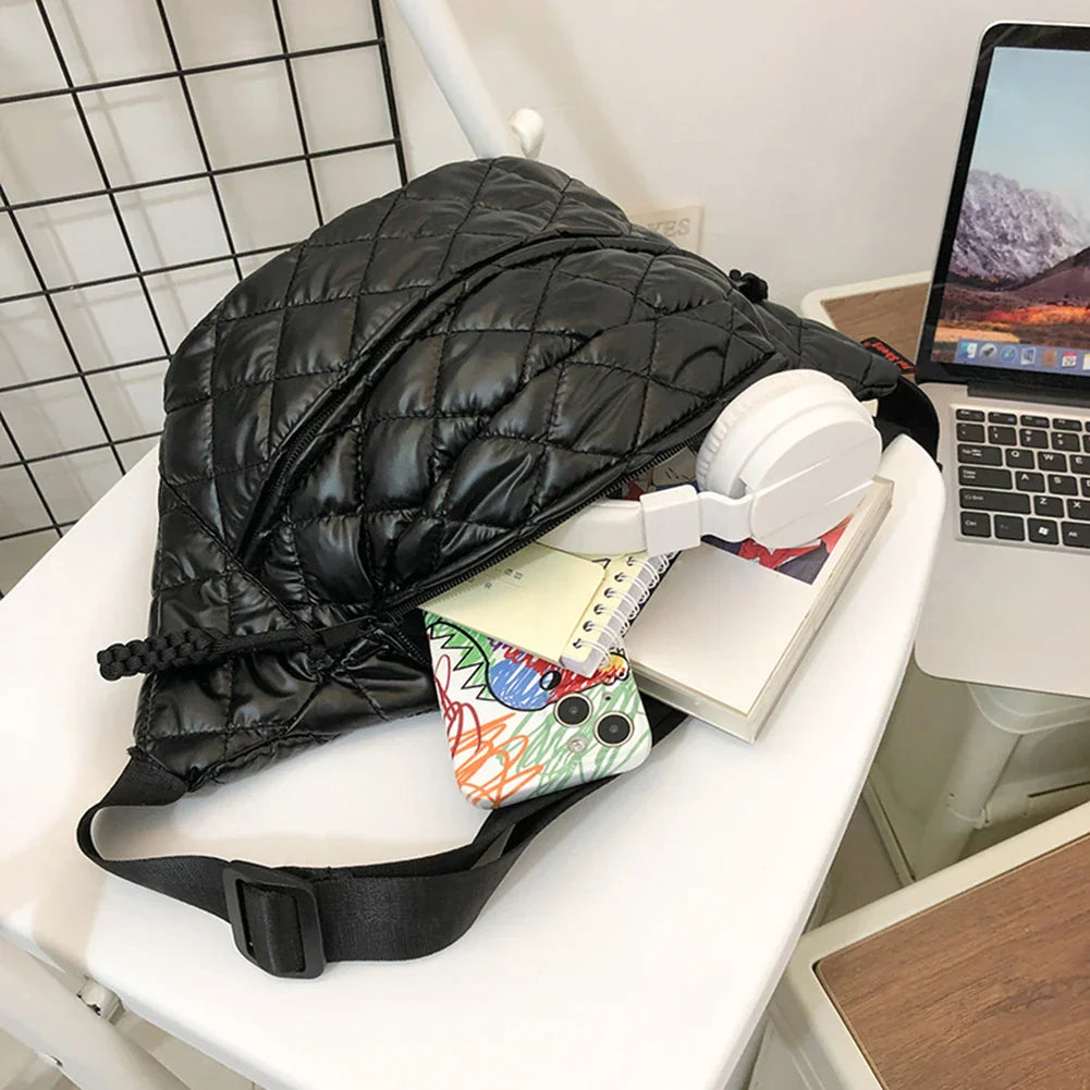 Zaino nero trapuntato su sedia bianca, con cuffie bianche, smartphone e quaderno colorato. Accessori moda, tecnologia, stile urbano.