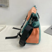 Borsa a tracolla multicolore in tessuto, design moderno con tasche laterali e cinghie regolabili, ideale per uso quotidiano e viaggi.