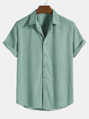 Camicia verde menta da uomo, maniche corte, colletto classico, bottoni frontali, tessuto leggero, ideale per look casual estivi.