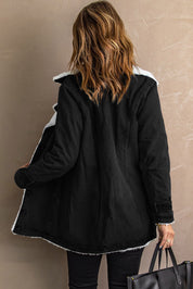 Donna di spalle con cappotto nero invernale foderato di pelliccia sintetica, capelli castani ondulati, borsa nera. Moda autunno inverno elegante.