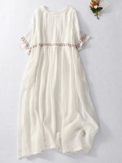 Abito lungo bianco in cotone, maniche corte con dettagli ricamati, stile boho chic, perfetto per l'estate.