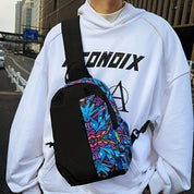 Zaino a tracolla nero con motivo graffiti colorato, indossato su felpa bianca. Accessorio urbano, moda streetwear, ideale per giovani.