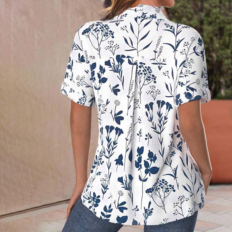 Camicia donna a maniche corte con stampa floreale blu su sfondo bianco, stile casual estivo, tessuto leggero, ideale per moda femminile.
