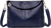 Borsa a tracolla in pelle blu scuro con chiusura a zip, dettagli in metallo dorato e ciondolo decorativo. Elegante e versatile per ogni occasione.