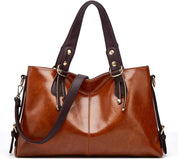 Borsa a mano in pelle marrone lucida con manici e tracolla regolabile, dettagli in metallo dorato. Elegante accessorio moda donna.
