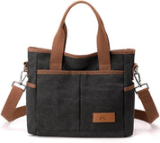 Borsa a tracolla in tela nera con manici marroni, tasche frontali e tracolla regolabile. Design casual, ideale per uso quotidiano e viaggi.