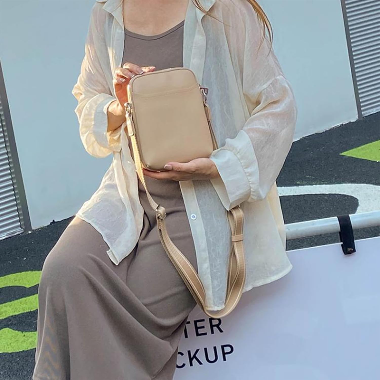 Donna con borsa a tracolla beige, abbigliamento casual, camicia bianca trasparente, abito lungo marrone. Moda femminile, accessori eleganti.