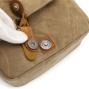 Borsa a tracolla in tela marrone con chiusura magnetica in pelle, dettaglio di fibbia in metallo. Design vintage, resistente e alla moda.