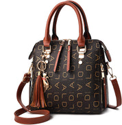 Borsa a mano in pelle marrone con stampa monogramma, dettagli dorati, ciondolo decorativo e tracolla regolabile. Elegante e alla moda.