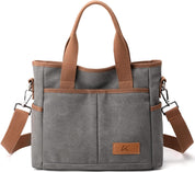 Borsa a tracolla in tela grigia con manici marroni, tasche esterne e tracolla regolabile. Design elegante e funzionale per uso quotidiano.