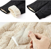 Giacca invernale nera con fodera in pelliccia sintetica beige, dettagli su polsini e tessuto impermeabile. Abbigliamento caldo e resistente.