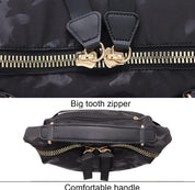 Zaino nero con cerniera a denti grandi e manico comodo, design mimetico, dettagli in metallo dorato, ideale per viaggi e uso quotidiano.