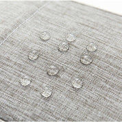Tessuto impermeabile grigio con gocce d'acqua, resistente e idrorepellente, ideale per arredamento e rivestimenti esterni.