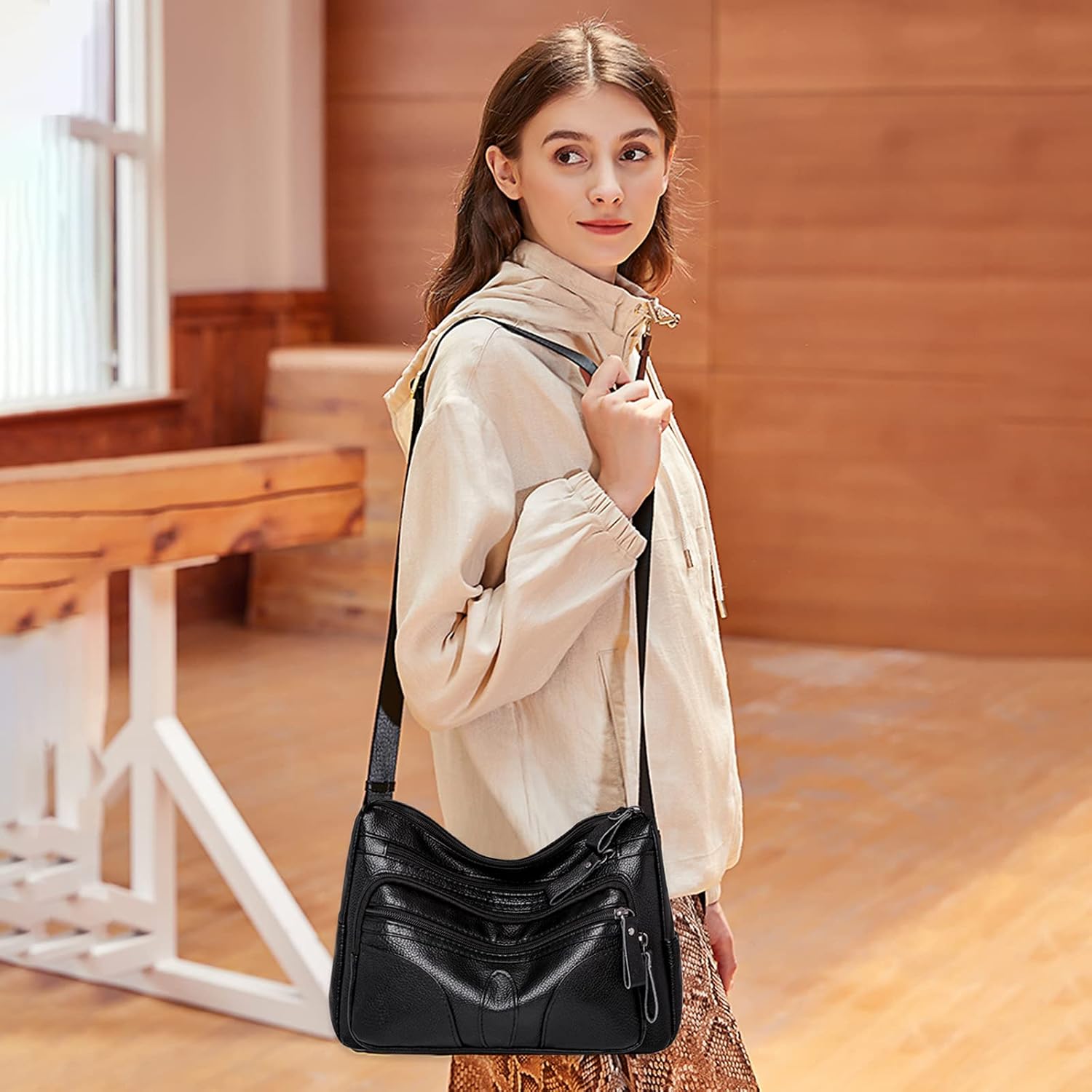Donna con borsa a tracolla in pelle nera, design elegante e moderno, indossa giacca beige. Accessorio moda femminile, stile casual chic.