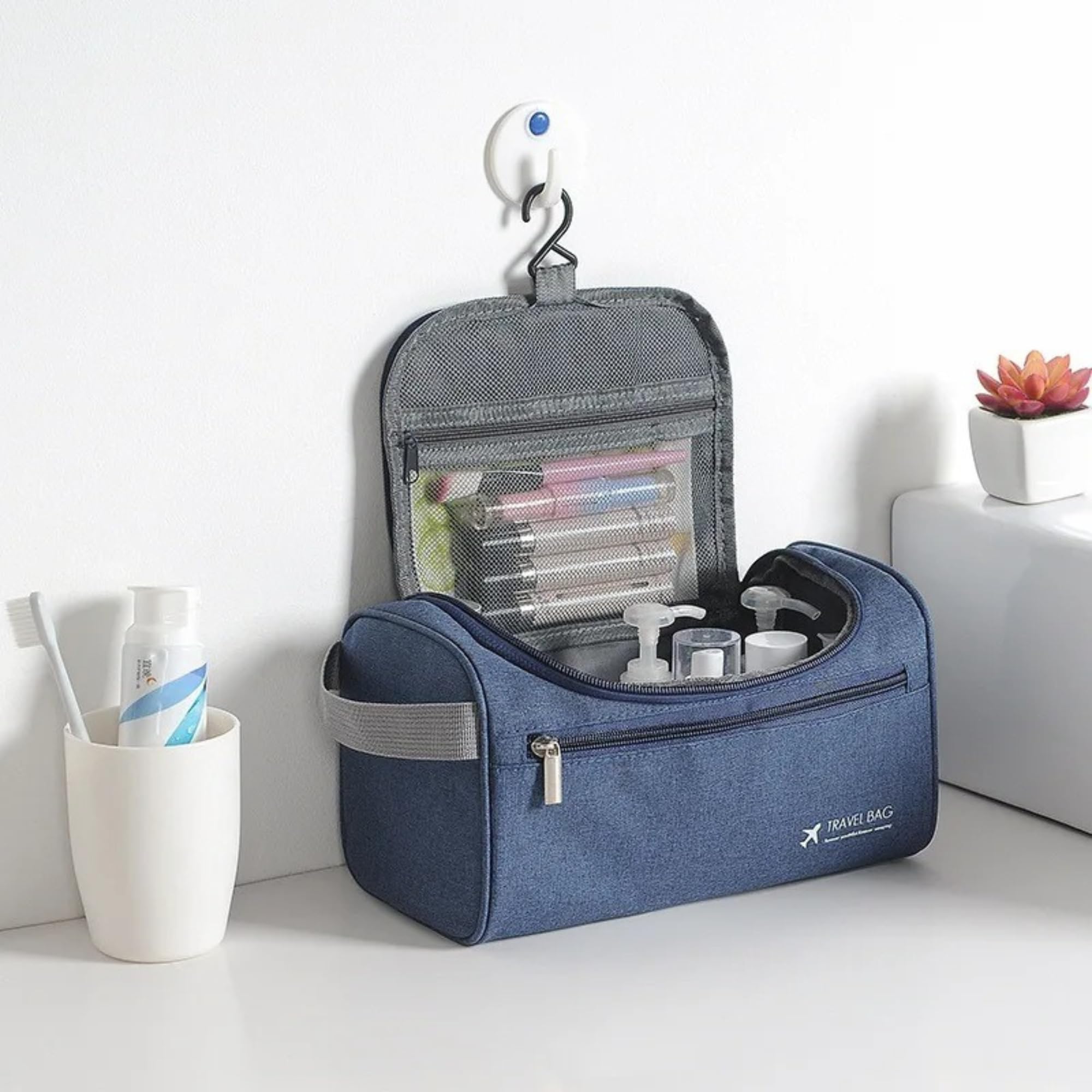 Borsa da viaggio blu con gancio, tasche trasparenti, contenente articoli da toeletta. Design compatto, ideale per organizzare prodotti personali.
