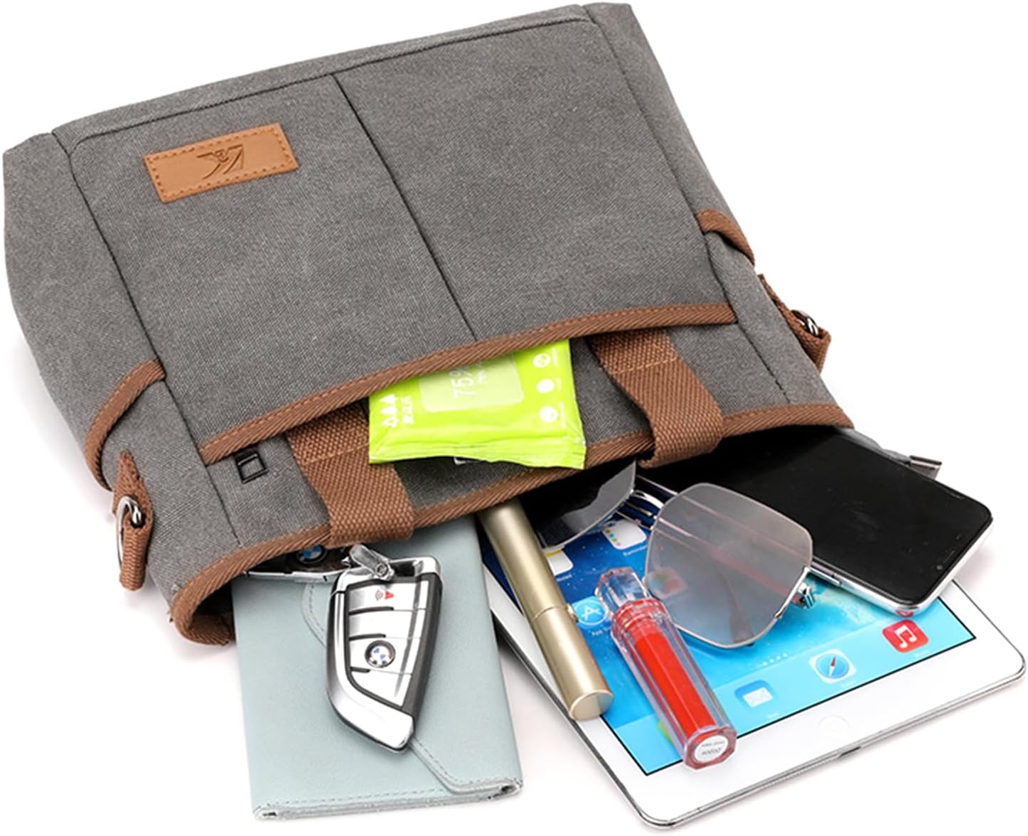 Borsa a tracolla in tela grigia con tasche multiple, contenente smartphone, tablet, occhiali da sole, chiavi e accessori. Design pratico e moderno.